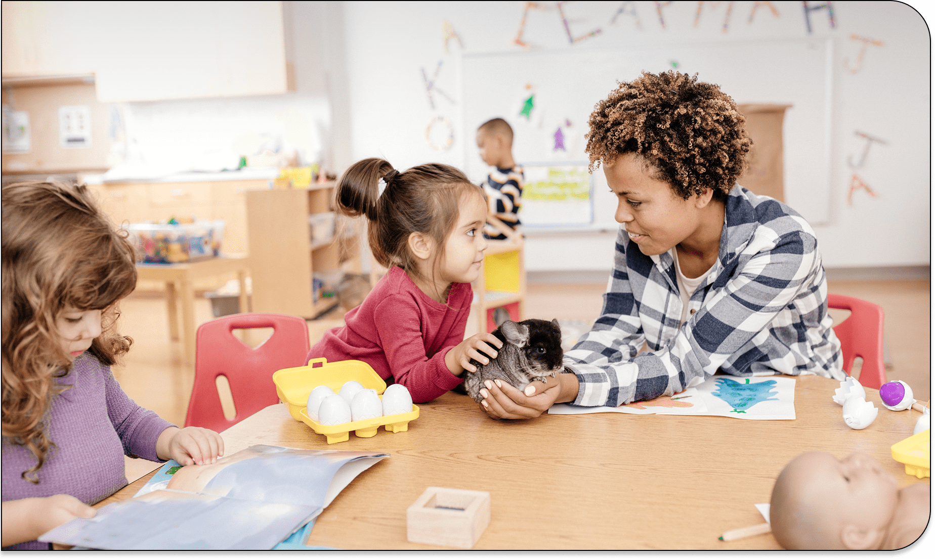 Children and teacher interacting with kitten