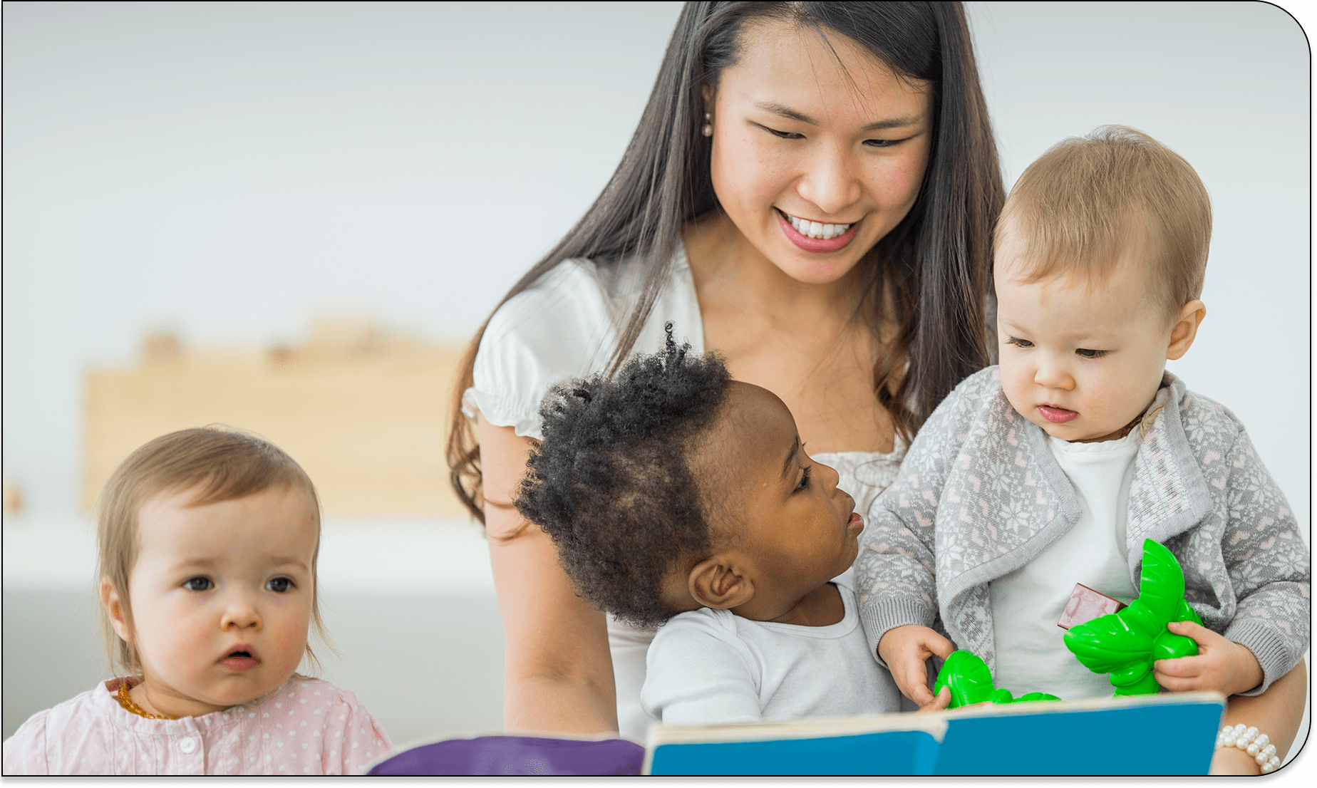 Smiling caregiver with three toddlers